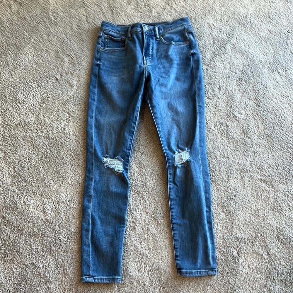 Express medium wash high rise skinny jeans with distressed knees.